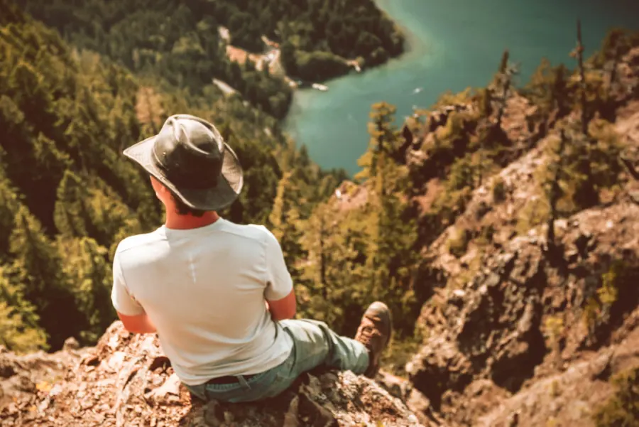 A young man sitting on a cliff above a lake on the Olympic Peninsula